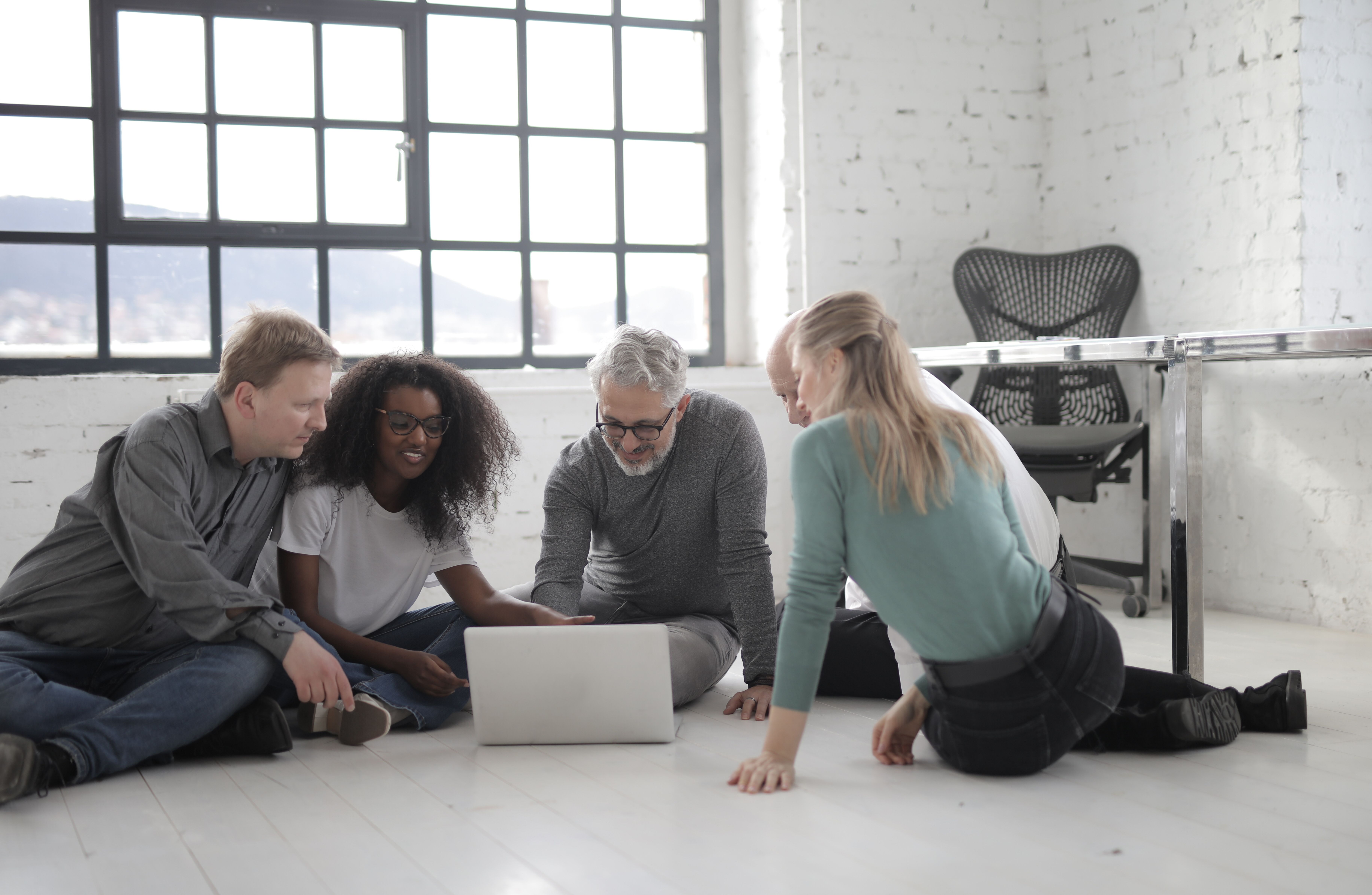 team of workers working together using a laptop