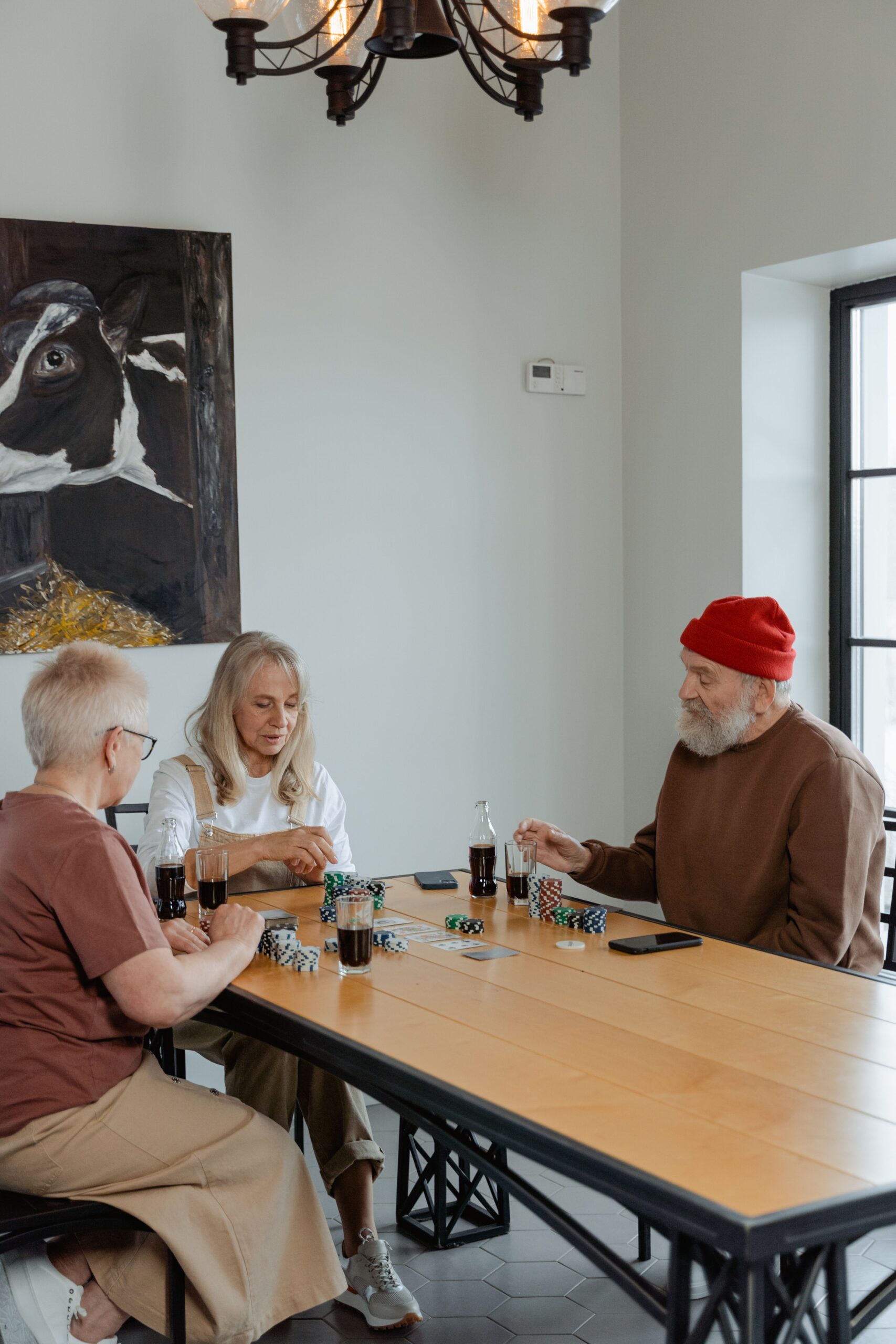 3 senior citizens sitting on a table chatting to each other